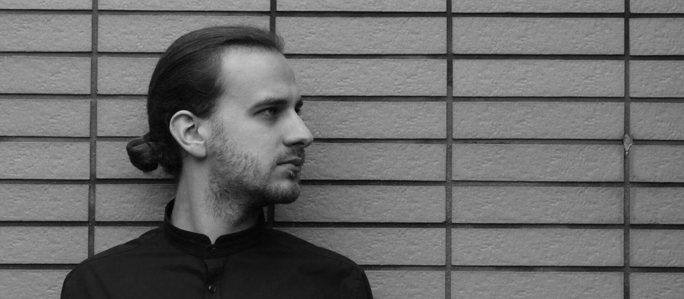 Martin Spahr im Profil vor einer Fliesenwand, Schwarzweißfoto